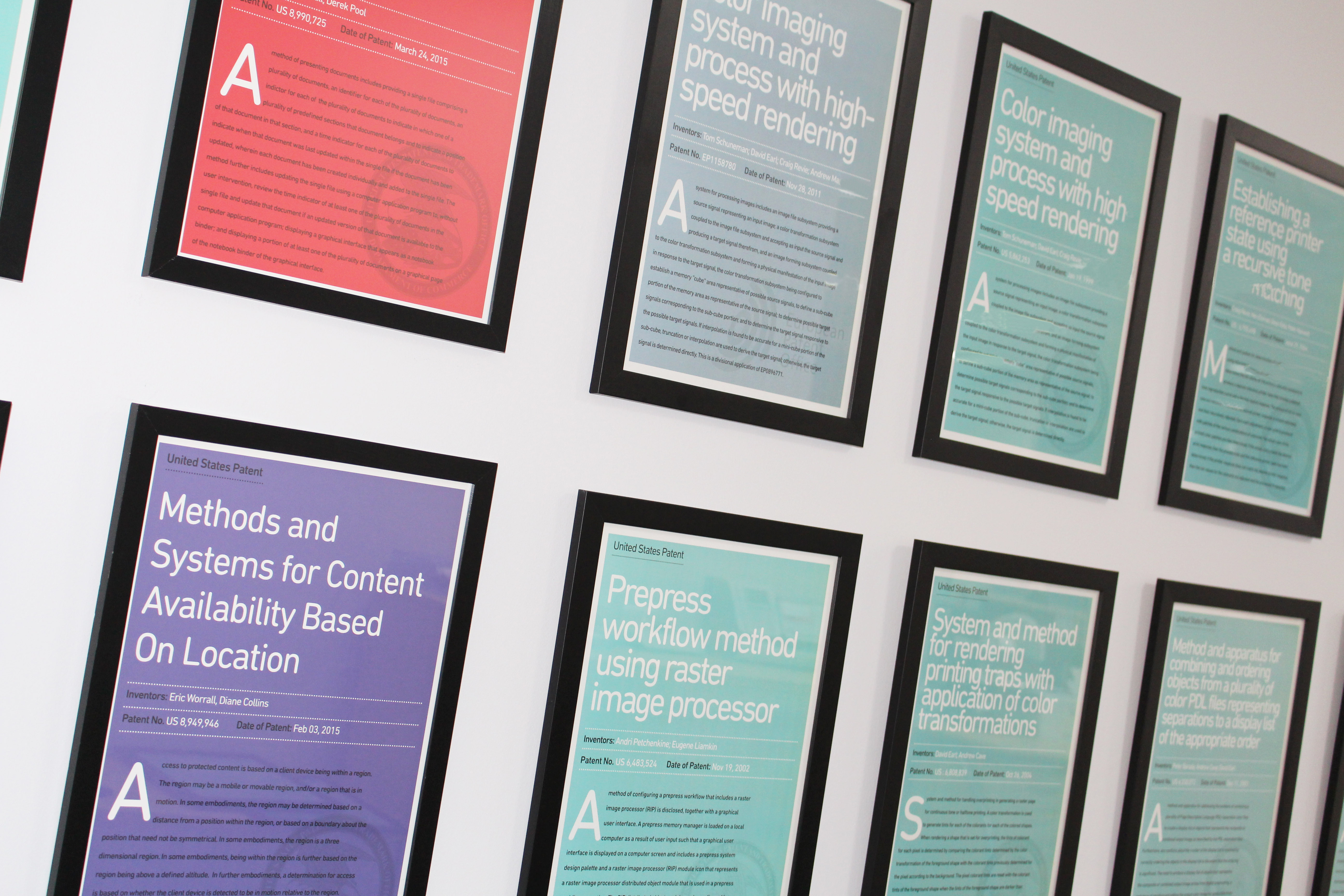 Framed patent certificates mounted on office wall