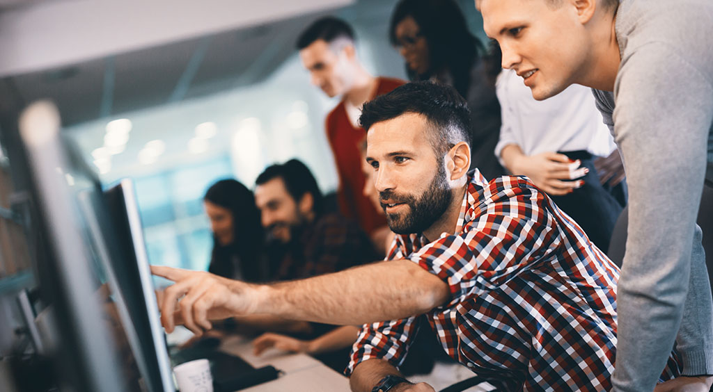 Placeholder image showing collaborating individuals around a computer screen